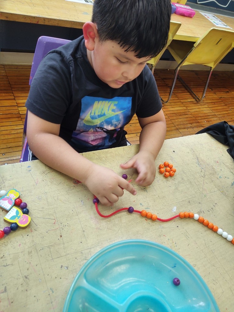 K & 1 exploring patterns with beads.