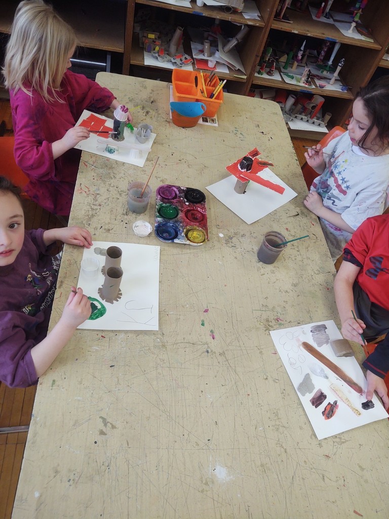 Kindergarten artists painting their recycling sculptures.
