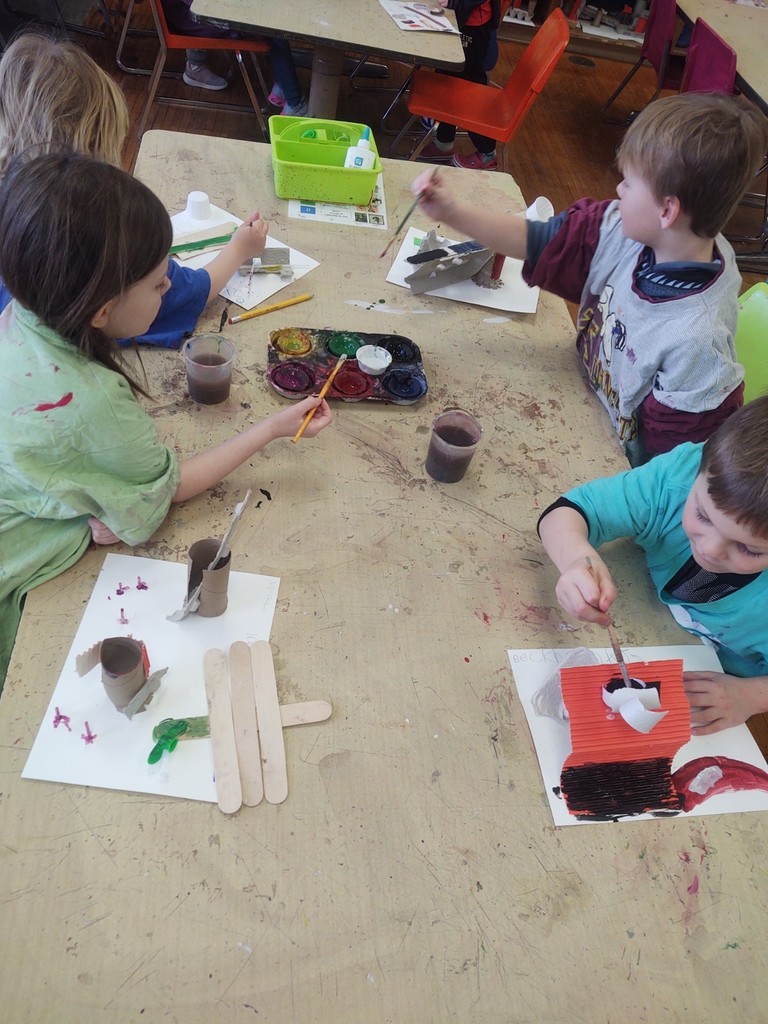 Kindergarten artists painting their recycling sculptures.